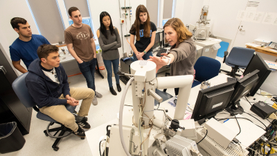 students gather around an electron microscope at Duke University