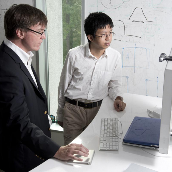 Professor John Dolbow and graduate student Yinglie Liu look at research on a computer screen