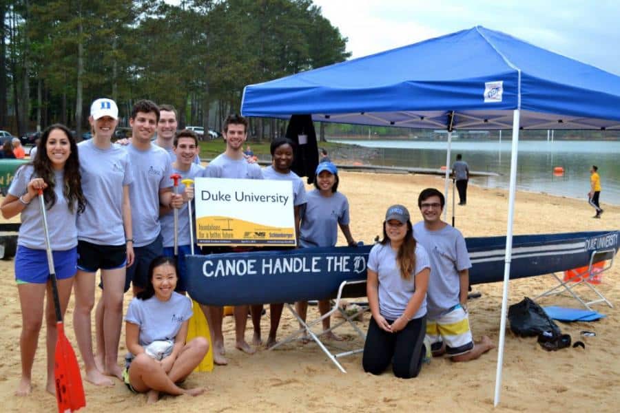 students pose with a canoe made of concrete