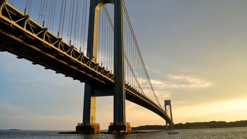 Students cross a wooden suspension bridge in the jungle with low overhanging clouds
