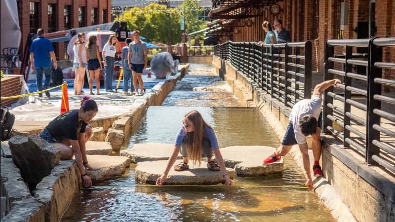 students measure the width of a water channel