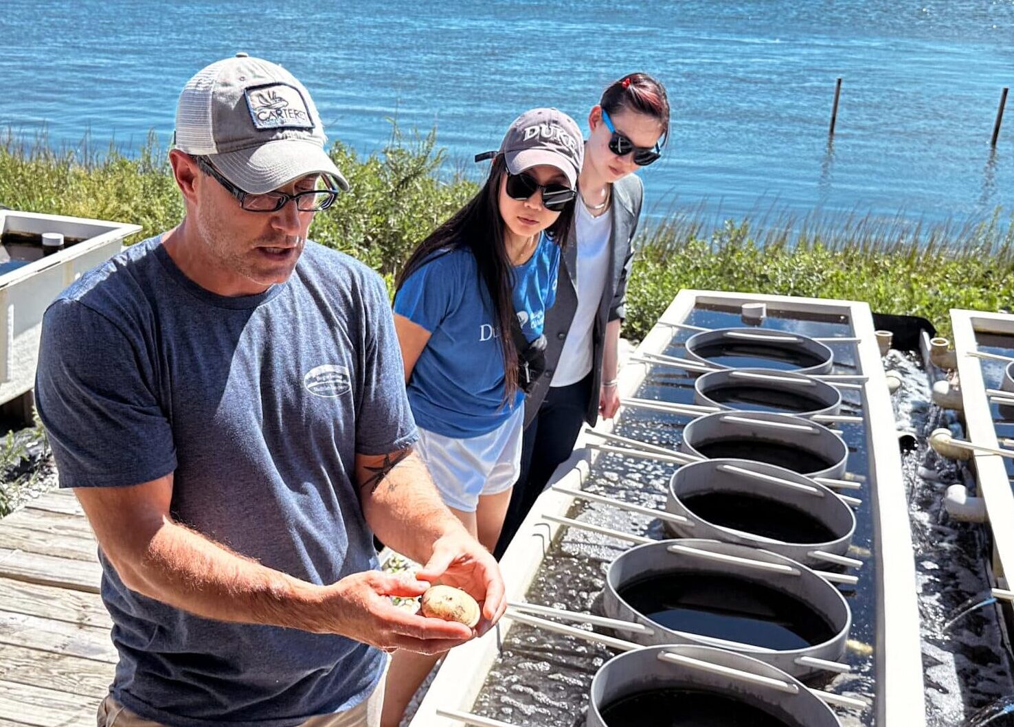 people look at experimental equipment dockside at a marine laboratory