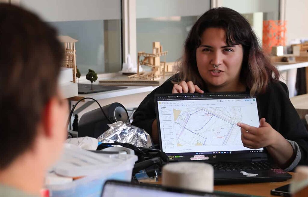 a person holds and points to a digital tablet