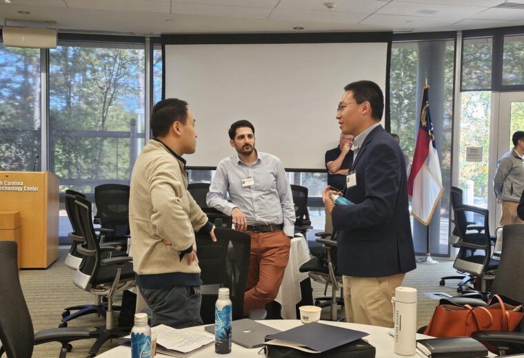 people stand and talk in a conference room