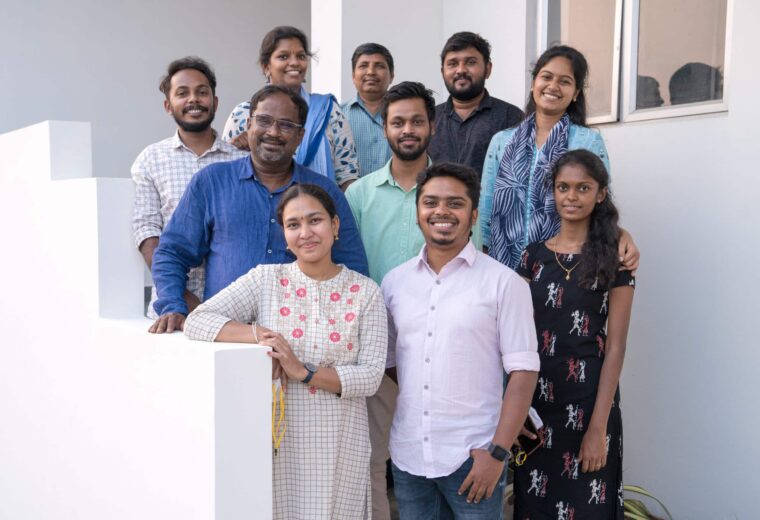 A group of brown people standing together on stairs