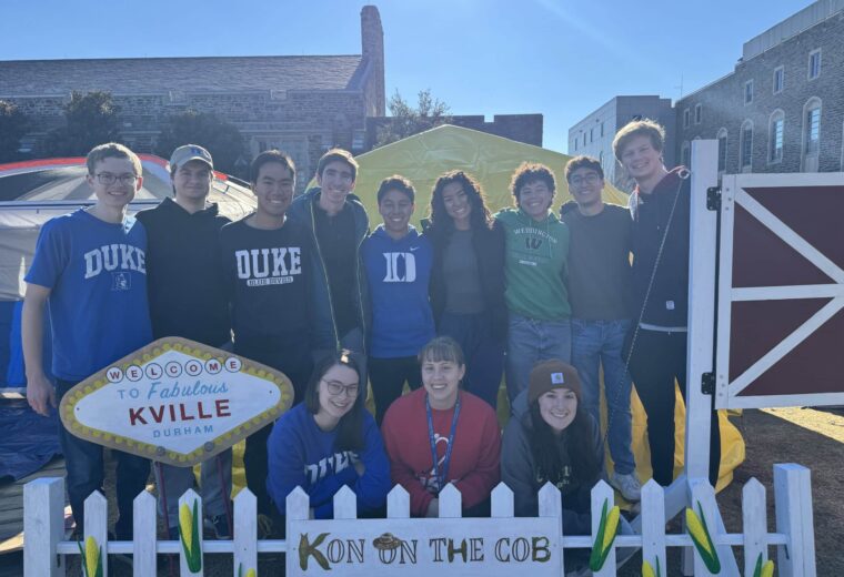 12 people stand and kneel behind signs with titles Kon the Cob and Welcome to Fabulous Kville